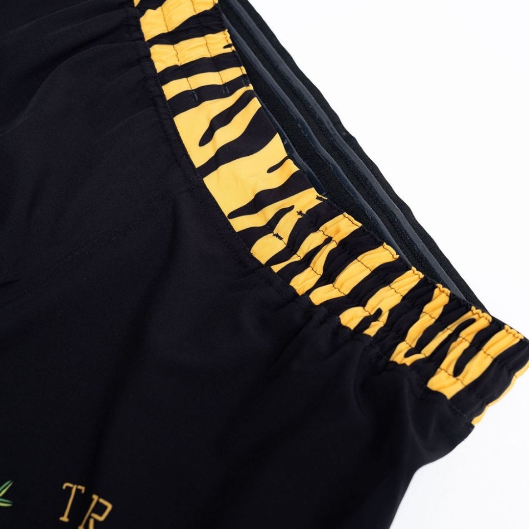 True Illusion BJJ Shorts - Tiger, close-up of tiger-stripe elastic side panel and hem detail in gold and black