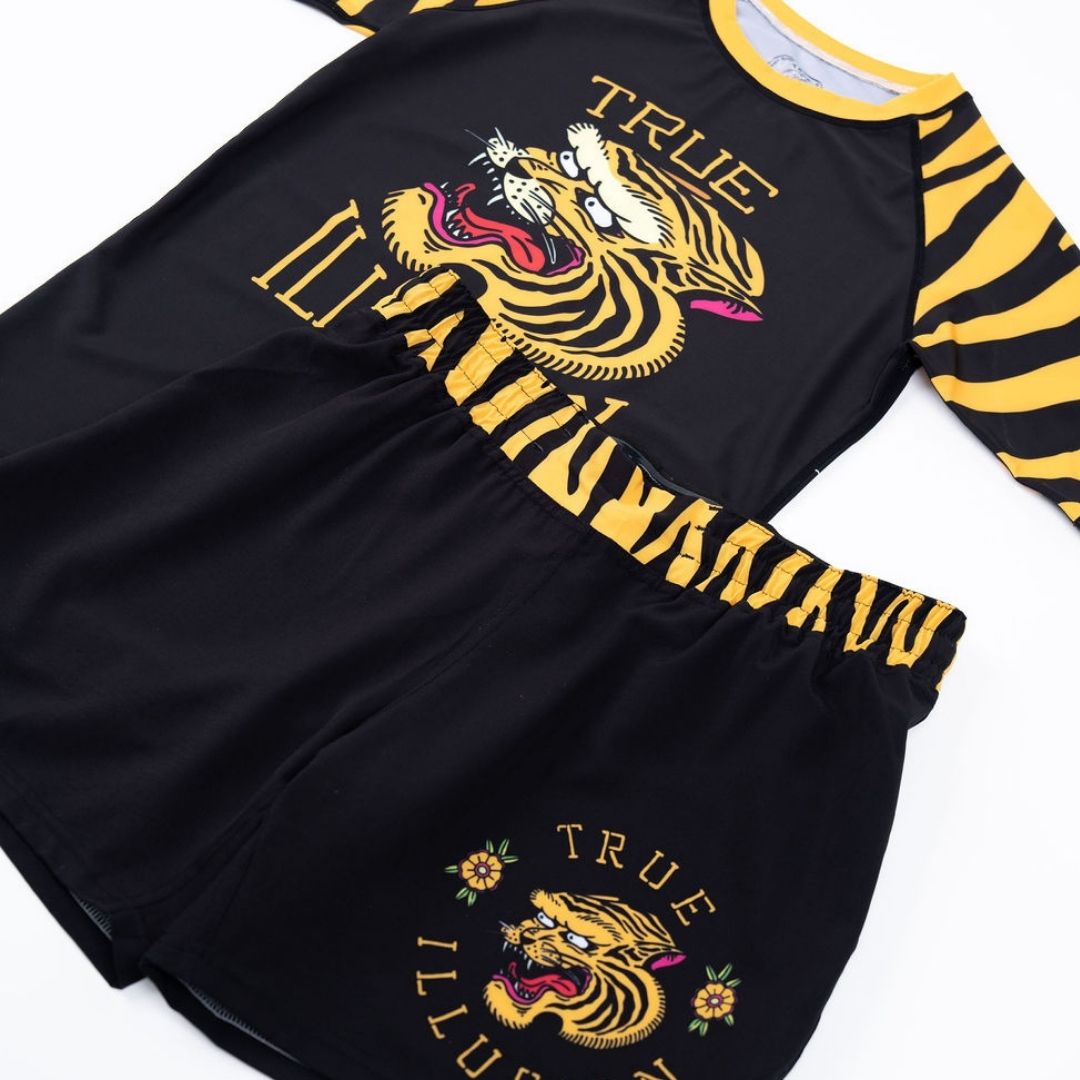 True Illusion BJJ Shorts - Tiger, flat lay front view showing tiger graphic and yellow tiger-stripe waistband, paired