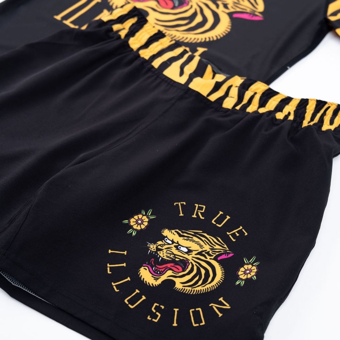 True Illusion BJJ Shorts Tiger, close-up of leg panel showing gold tiger head graphic, floral accents, and arched True